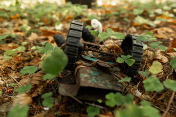 An old, abandoned toy left in the forest. Rusty, children's typewriter in the autumn foliage.