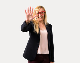 Middle-age blonde business woman with black jacket counting five with fingers on isolated grey background