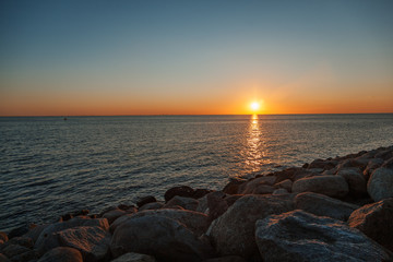 Beautiful sea sunset, the sun sets behind the horizon, a minimalistic landscape