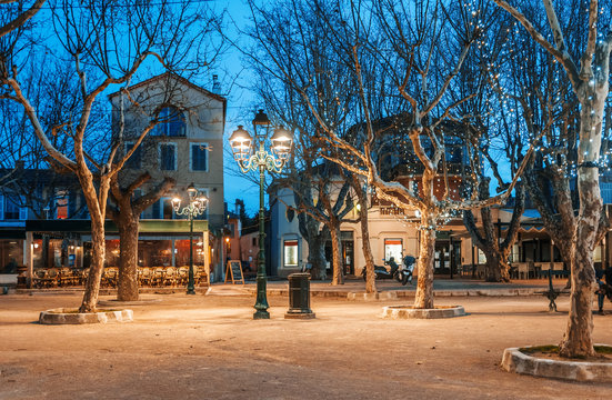 Fototapeta Beautiful night cityscape, tree illumination, lights and benches, central square Saint-Tropez, Provence, France