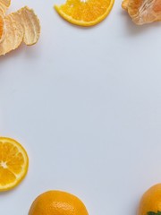 Sliced and peeled orange on white background and arranged around of frame with copy space