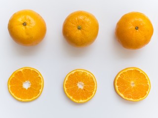Sliced and whole orange on white background and arranged around of frame