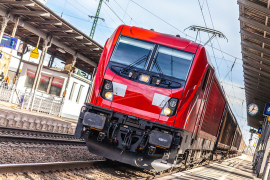 Fototapeta german freight train passes a train station