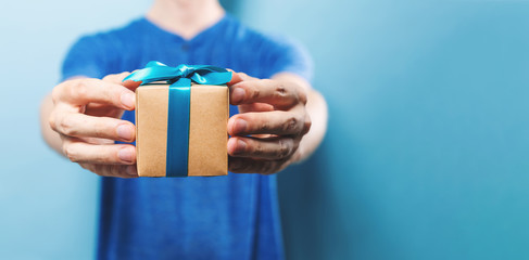 Man holding a gift box on a blue background
