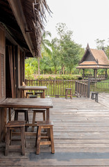Obraz premium Old traditional house in Thai style with wooden pavilion in the middle lake.