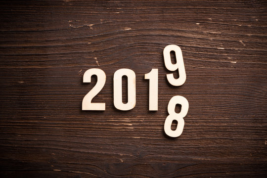 symbolischer Jahreswechsel zwischen 2018 und 2019 auf rustikalem Holzuntergrund 