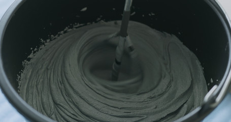 closeup mixing dark gray micro concrete plaster