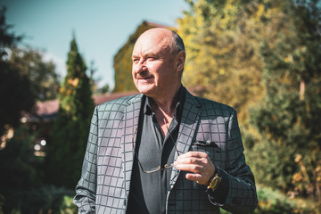 Mature European or American man with a good mood, outdoor portrait. The concept of life after 50-60...