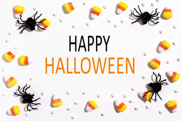Happy Halloween message with spiders overhead view on a solid color