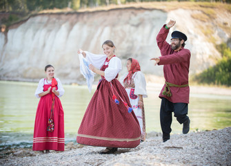 Young people in Russian national costumes dancing authentic moves