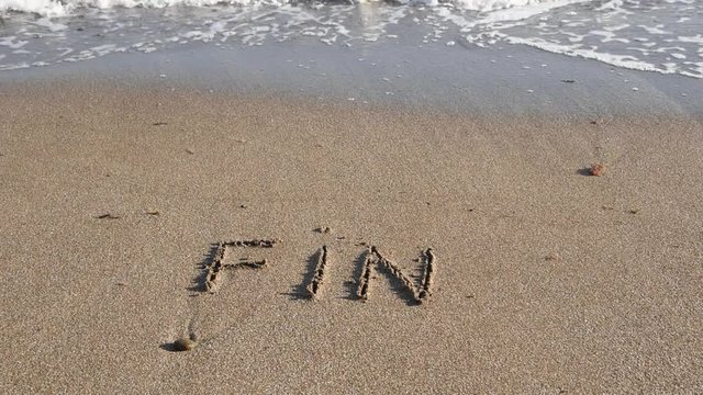 French word &ldquo;fin&rdquo; (end) on the sand and a wave that erase this word