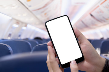Airplane passenger using smart phone on plane. Businessman touching blank screen mobile phone at...