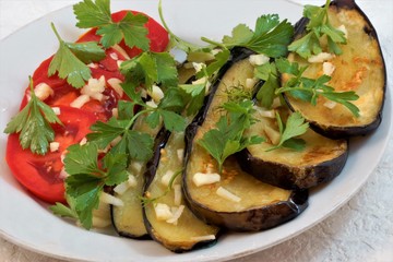 Fried eggplant with tomatoes, garlic and herbs, delicious and healthy food. Breakfast, lunch and dinner, holiday.