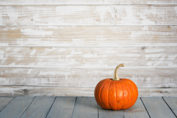 Pumpkin on wooden wall background. Halloween and autumn food concept