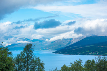 Naklejka na ściany i meble Beautiful fjord. Mountain slopes go down to the sea. The beautiful nature of Norway