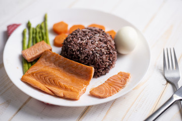 Health food concept, salmon with rice and vegetable on wood background