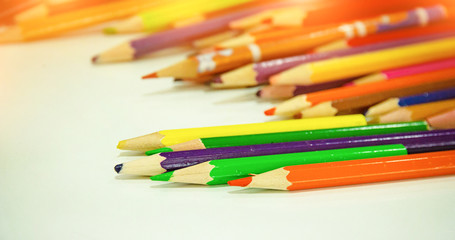 In selective focus of used color pencil put on desk,warm light tone,blurry light around