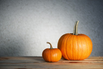 Two pumpkins on wooden table. Halloween and autumn food background