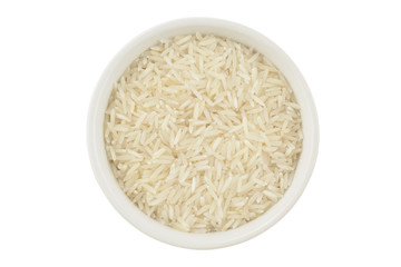 Arroz basmati en un bol de cerámica blanca silueteado sobre fondo blanco, top view