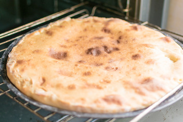 Pie with cheese, khachapuri in the oven.