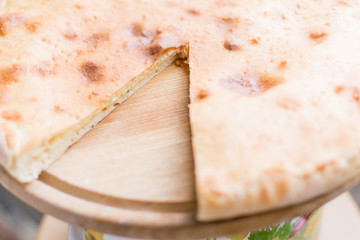 Pie with cheese, khachapuri on a wooden background.