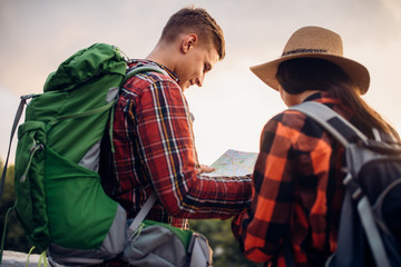 Hikers looks on map, excursion in tourist town