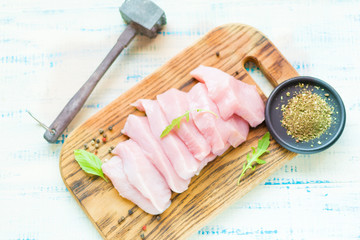 Raw meat fillet of turkey, chicken sliced on a wooden board.