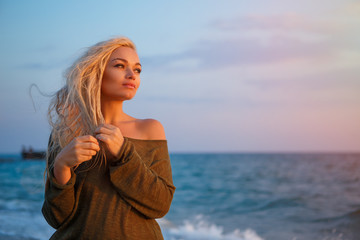 Fototapeta na wymiar portrait of a beautiful girl on the beach at sunset
