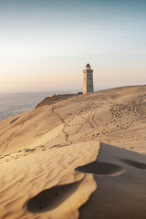 Famous danish Lighthouse and coastline sand dunes is a popular travel trip. Landscape in colorful...
