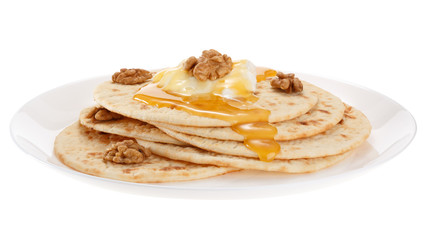 Cakes with sour cream, honey and nuts on a plate. Isolated on white background.