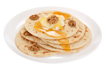 Cakes with sour cream, honey and nuts on a plate. Isolated on white background.