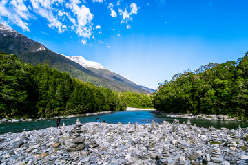 Stunning scenery of the nature and heap of stack rocks beside the river. Snow mountain and green mounntain landscape.