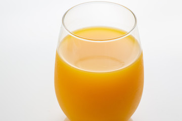 Fresh squeezed orange juice right off a tree into the glass on white kitchen table ready for breakfast in the morning