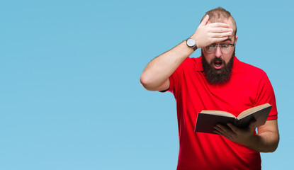 Young hipster man wearing glasses and reading a book over isolated background stressed with hand on...