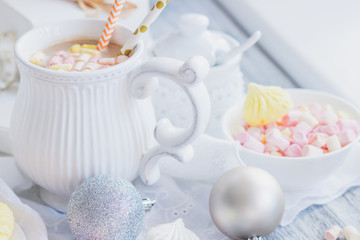 Cup of cacao with marshmallow, meringues and different Christmas decorations