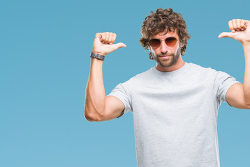 Naklejka premium Handsome hispanic model man wearing sunglasses over isolated background looking confident with smile on face, pointing oneself with fingers proud and happy.