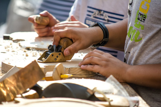 Children learn to make custom violin and other musical instruments in outdoor fablab classes. Joiner's training on makerfaire.