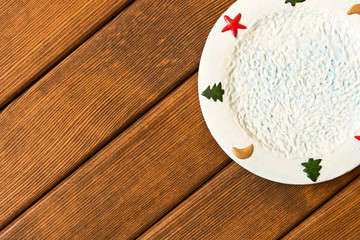 Christmas plate on a wooden table. The concept of Christmas. Empty space for text
