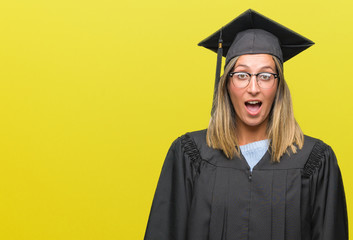 Young beautiful woman wearing graduated uniform over isolated background afraid and shocked with surprise expression, fear and excited face.