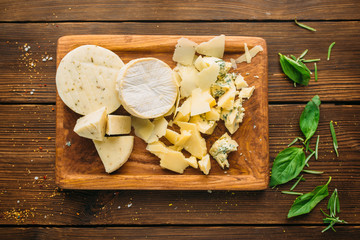 Cheese and herb on wooden table closeup, nobody