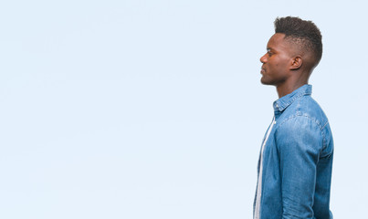 Young african american man over isolated background looking to side, relax profile pose with...