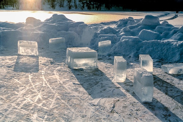 Solid, transparent ice blocks standing on frozen water on a cold, frosty winter day