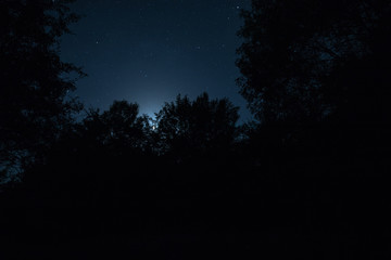 Mountain Road through the forest on a full moon night. Scenic night landscape of dark blue sky with moon. Azerbaijan