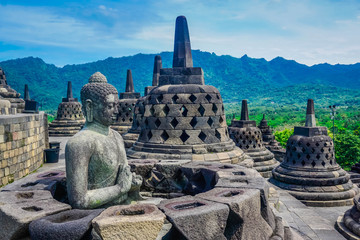 The statue of Buddha on one of the ancient temples of the World - the temple of Borobudur. Indonesia - obrazy, fototapety, plakaty