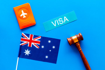 Visa to Australia concept. Text visa near passport cover and australian flag, hammer on blue...