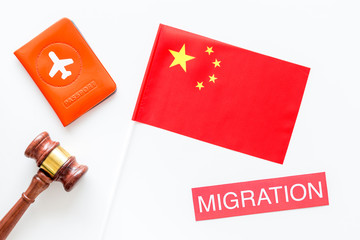 Immigration to China concept. Text innigration near passport cover and chinese flag, judge hammer on white background top view copy space