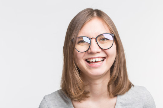 Portrait of laughing happy brown hair girl in a glasses over white background