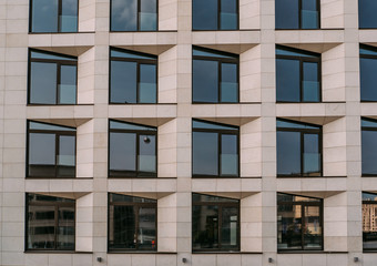 Abstract facade of new modern building wall with windows, house exterior