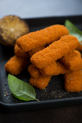 Close-up of fried fish sticks or breaded fish fillet, selective focus, vertical shot