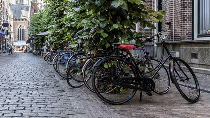 Fototapeta na wymiar Multiple bicycles parks on a typical old Dutch street 